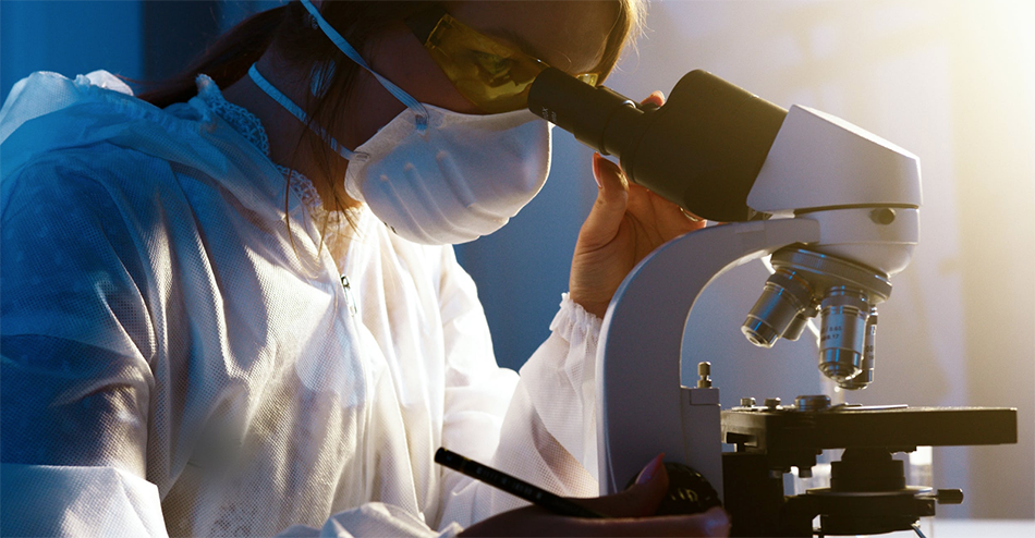 woman researcher looking through microscope